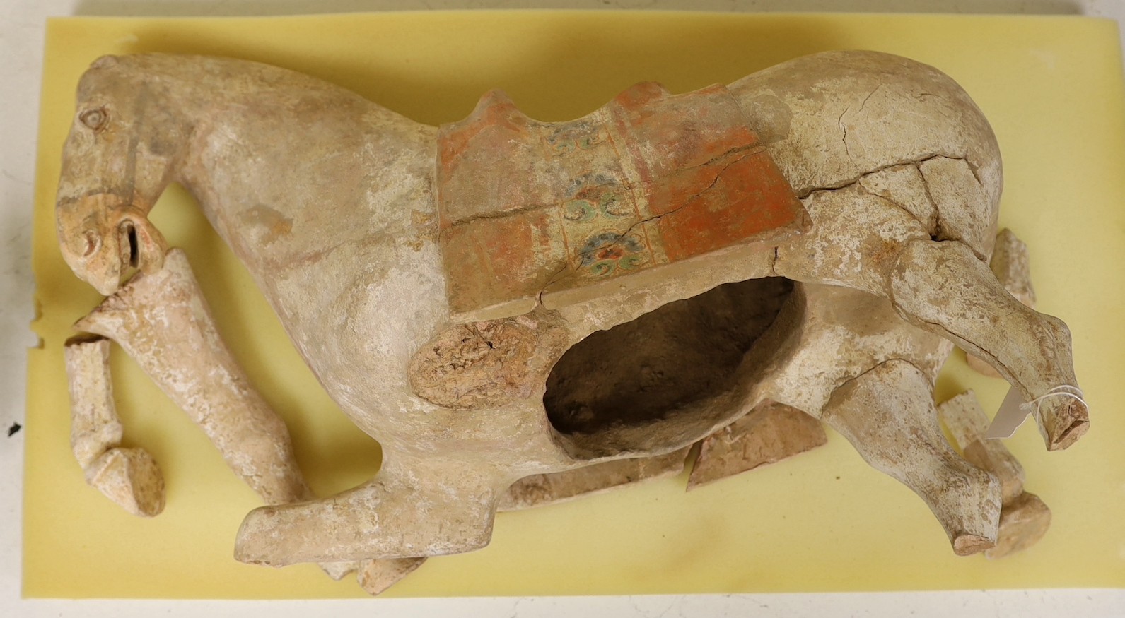 A large Chinese pigment painted pottery model of a saddled horse, Tang dynasty, incomplete, body approximately 58cms long